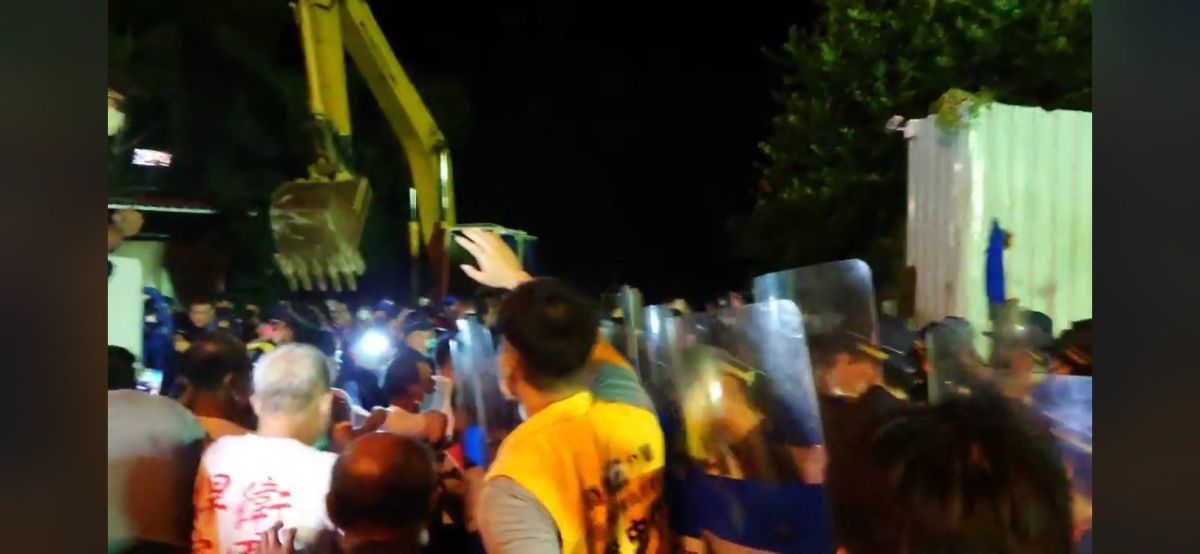 ▲立委指控苗栗坤輿掩埋場為今、明兩天要進行試營運而發動夜襲，欲排除自救會設在門口的石塊，大批黑衣人從場內竄出，挖土機先移除水泥塊，爆發流血衝突。（圖／翻攝自陳椒華臉書）