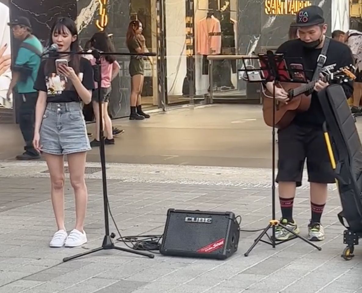 ▲一位長相甜美的正妹（左）在信義區街頭唱歌，結果五音不全讓路人相當錯愕。（圖/爆廢公社二館）