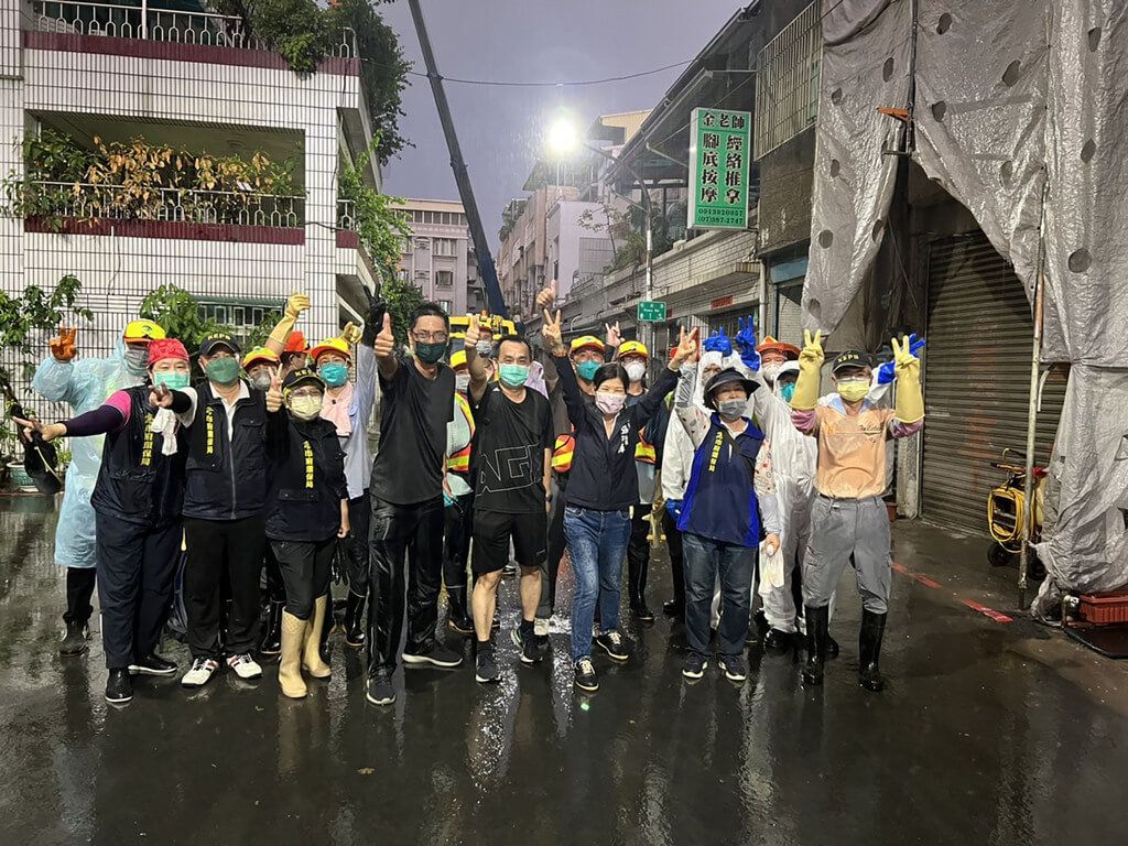 ▲高雄市三民區髒亂透天民宅自26日起展開清理作業，環保局共出動239名清潔員、近30車次垃圾車及回收車，5天來清出31.58噸垃圾，30日晚間總算大功告成，清潔人員在雨中開心留影。（圖／高雄市環保局提供）