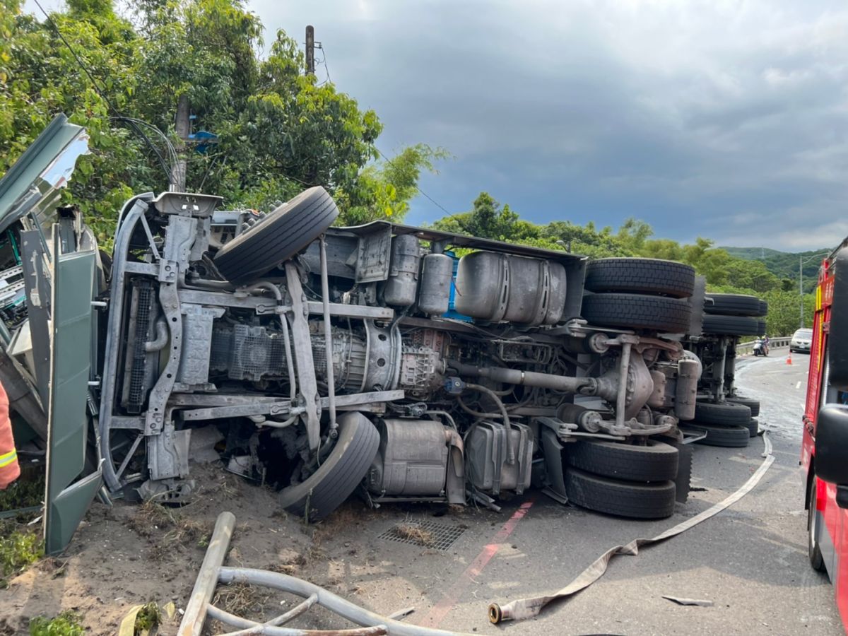 ▲貢寮區台2線99K處，今（1）日下午1點52分發生砂石車翻覆意外，駕駛一度受困車內，警消人員趕到後將其救出送醫。（圖／翻攝畫面）