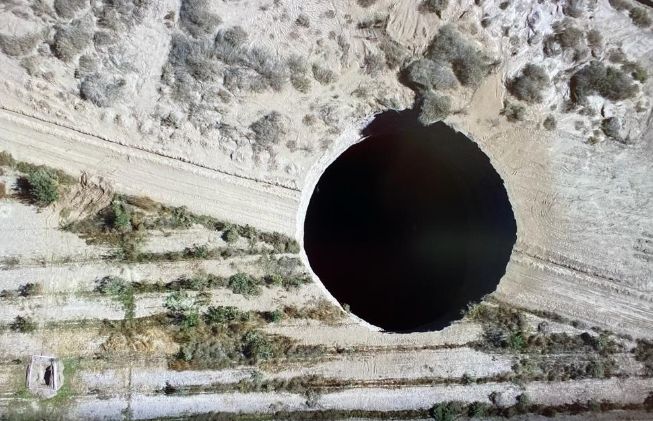 ▲智利北部一處銅礦場在週末赫然出現一個直徑約25公尺、深度約200公尺的神祕天坑。 （圖／翻攝自推特）
