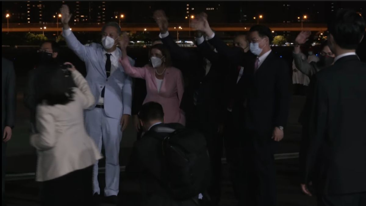 ▲裴洛西（著粉色衣服者）抵台，在台北松山機場向和群眾媒體們揮手致意。（圖／外交部）