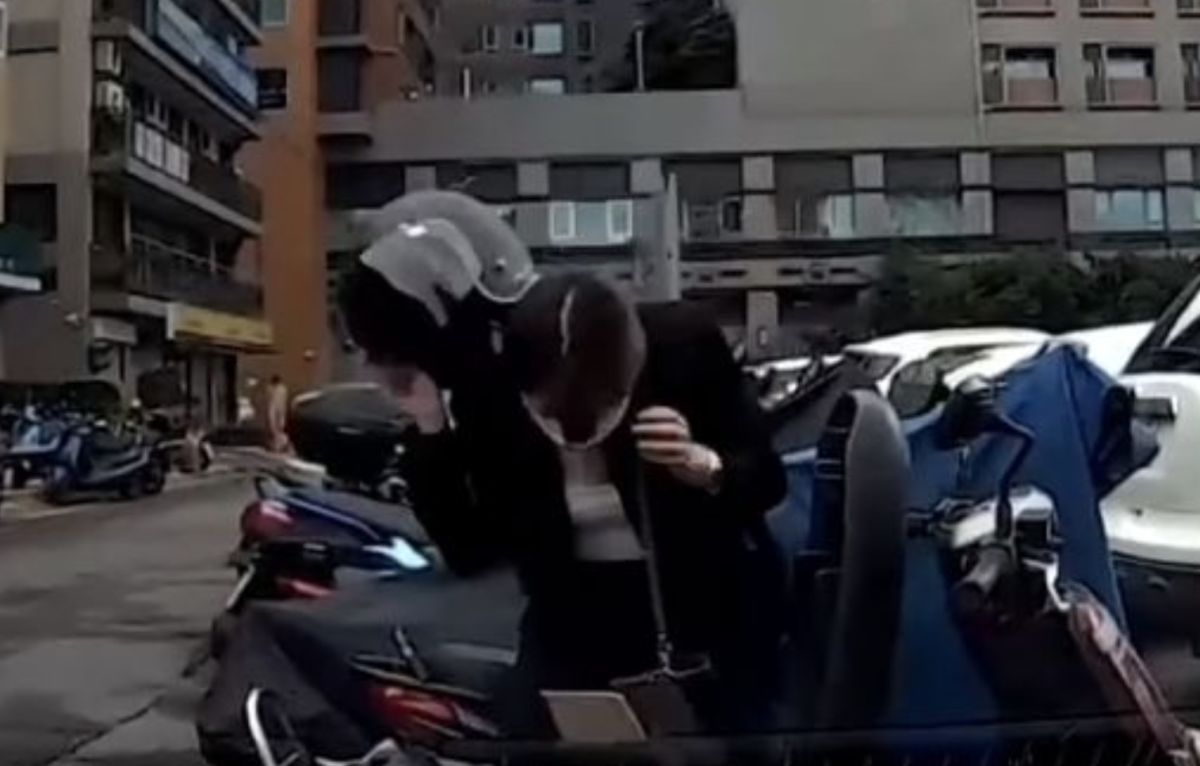 ▲一名女騎士因立中柱不穩擦撞轎車，低頭向車主道歉。（圖/重機車友 ❘ 各區路況、天氣回報中心）