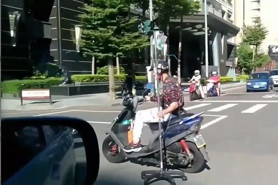 ▲台中阿伯單手騎車邊吊點滴,畫面嚇壞路人。(圖/翻攝自《爆廢公社》)