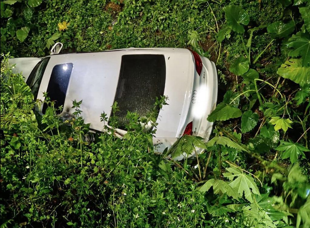 ▲南投縣警察局交通隊日前在埔里鎮靈巖山寺前設臨檢點，有員警要求一輛白色自小客車靠邊受檢，但駕駛卻拒檢駛離，隨後員警發現這輛自小客車因車速過快，掉入埔里醉翁山莊前方大溝渠內，立即通知消防隊派員救助。（埔里分局提供）中央社記者吳哲豪傳真 111年8月17日