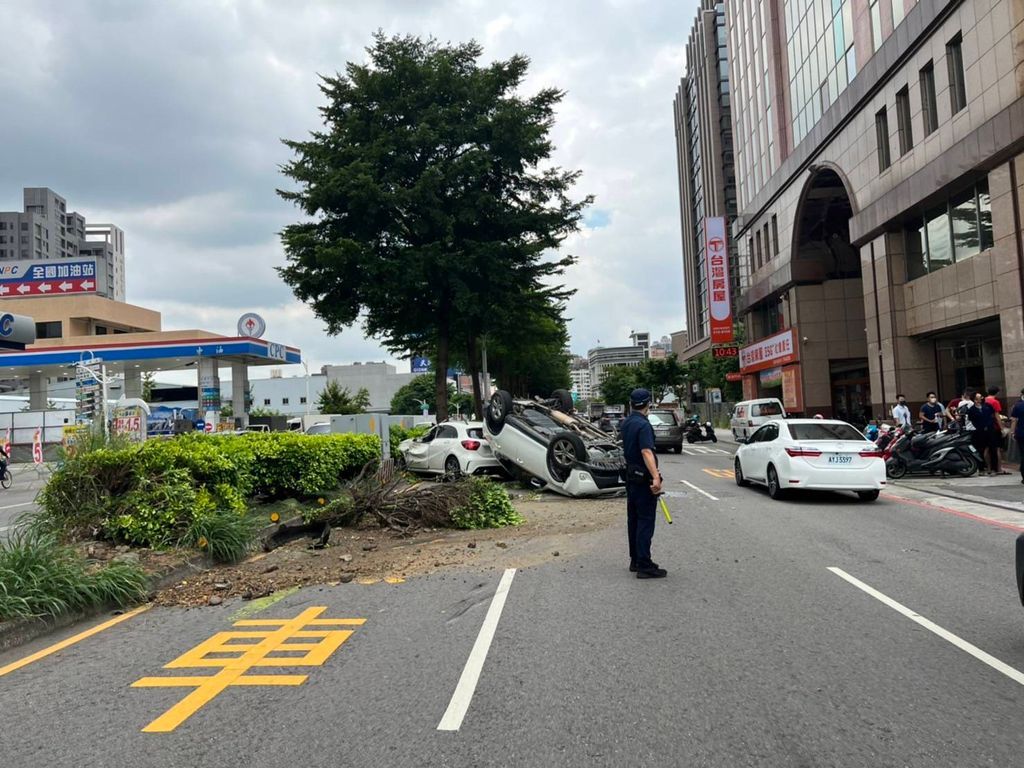 ▲周姓女子疑因誤踩油門，竟直接衝往分隔島，並撞上對向的直行轎車後翻覆。（圖／翻攝畫面）