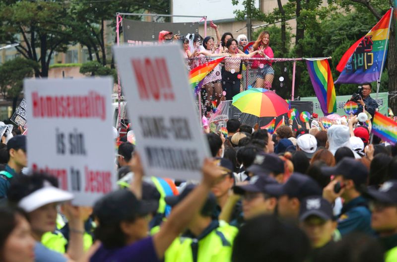 ▲韓國的LGBT族群參與同志遊行期間,遇上舉著反同標語的抗議人士。(圖/美聯社/達志影像)