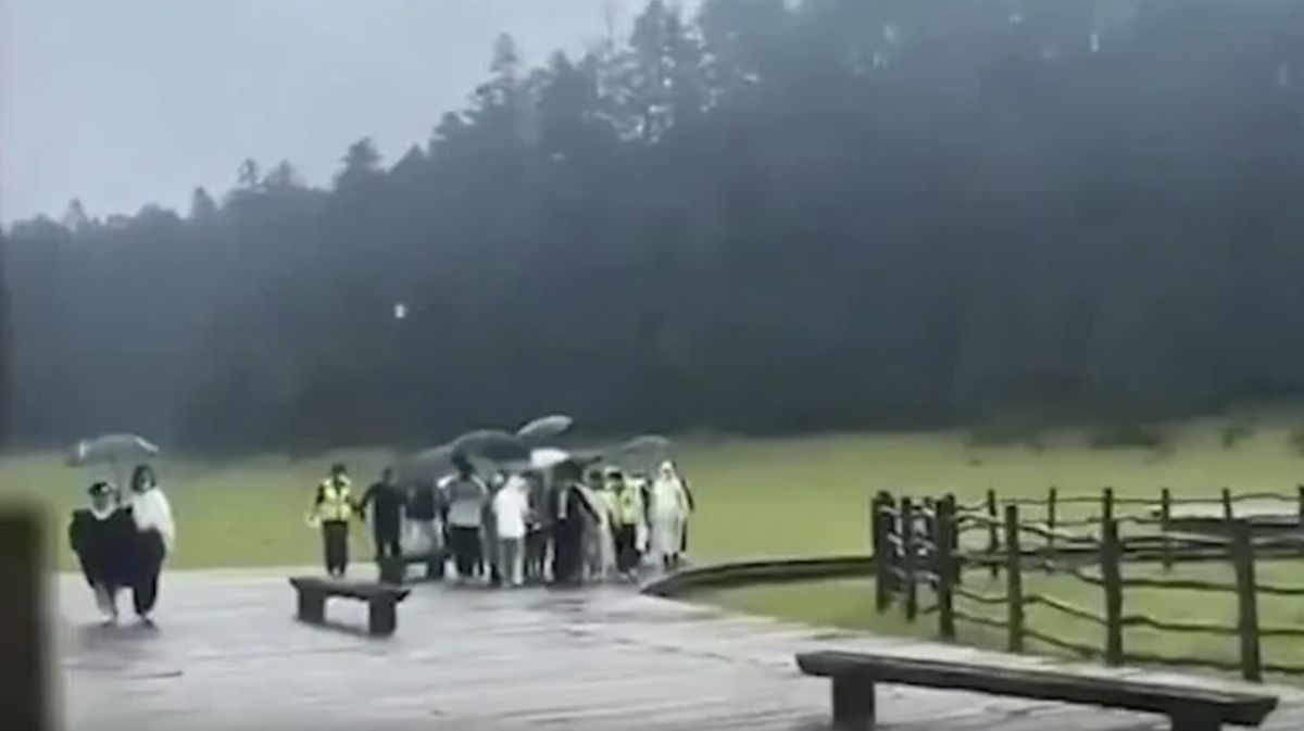 ▲24日下午15時許，玉龍雪山景區有一對新人正冒雨拍婚紗照。（圖／翻攝自澎湃新聞）