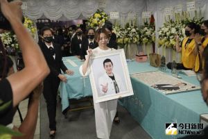 王瞳捧著艾成遺照比出「手勢7」。(圖/記者林敬原攝) ▲王瞳捧著艾成遺照比出「手勢7」。(圖/記者林敬原攝)