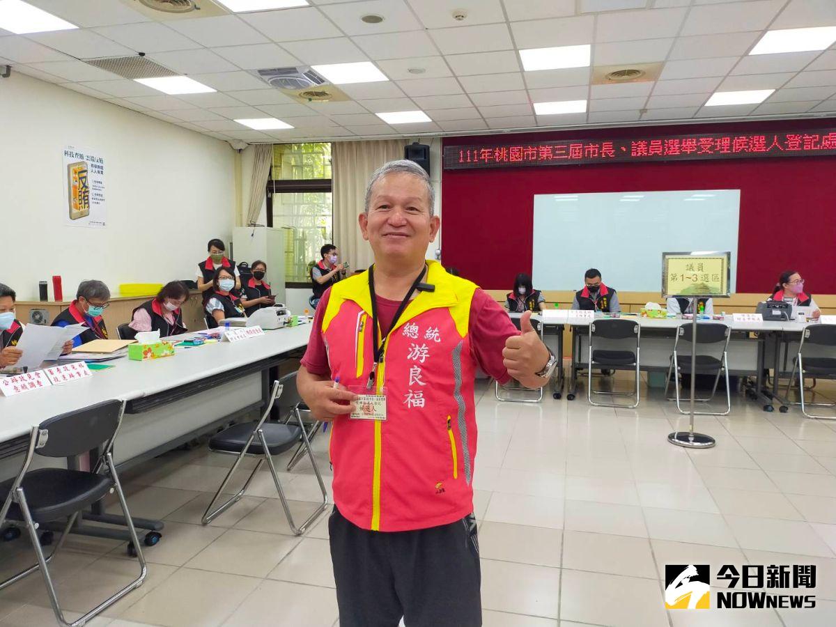 ▲游良福今日上午光著腳穿著自製「總統游良福」紅色小背心，走進桃園市選委會登記參選桃園市長。（圖／記者李春台攝，2022.08.29）