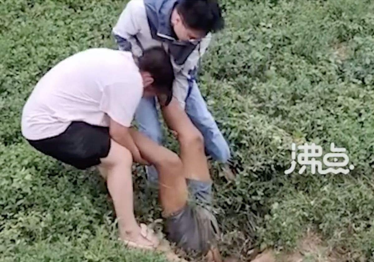 ▲中國一名女子在騎車途中，居然在草叢驚見一雙腿，害怕的她仔細查看才發現是一名老翁倒著插在土裡。（圖／翻攝自微博）