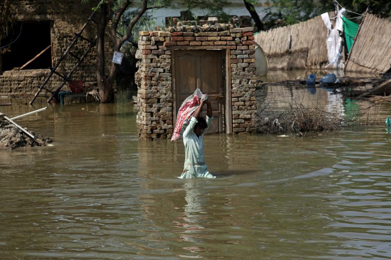 ▲巴基斯坦面臨空前洪災，使得當地印度河暴漲。圖為災情下的居民涉水而行。（圖／美聯社／達志影像）