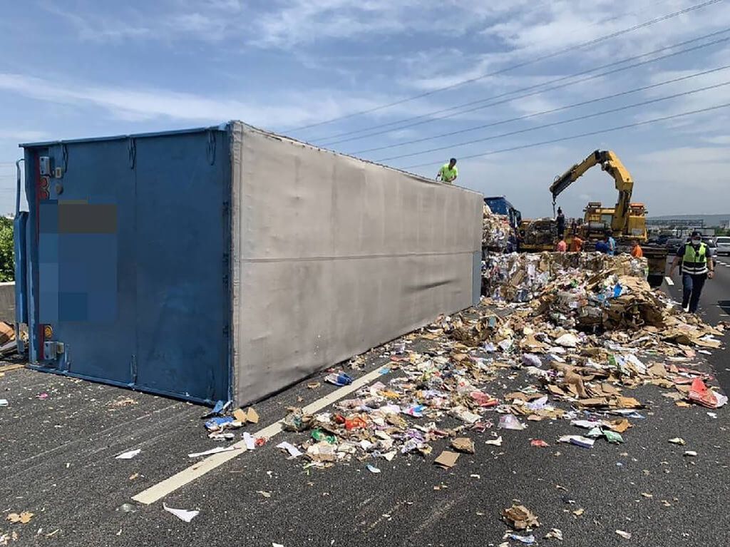 ▲國道一號北上彰化段1日發生一起聯結車翻車意外，警方表示，聯結車左前方車輪疑似爆胎，失控側翻在內線車道，占用內線及中線車道，現場路面更是散落大量廢紙。（圖／翻攝畫面）