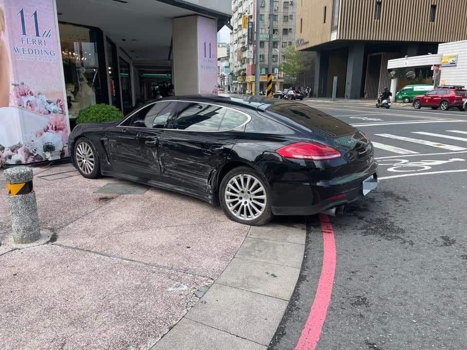 ▲高雄市新興區中正、林森路口，今（4）日早上一輛黑色保時捷與救護車擦撞，之後又衝上騎樓才停下。（圖／翻攝畫面）
