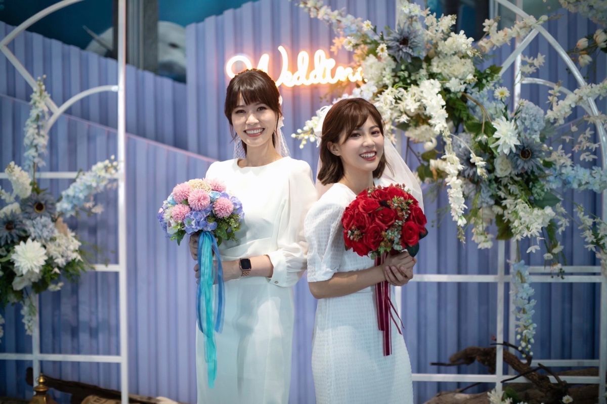▲兩位高市府發言人在唯一浪漫海洋風的「旗津戶政事務所」應景換上輕婚紗。(圖／高市府提供）