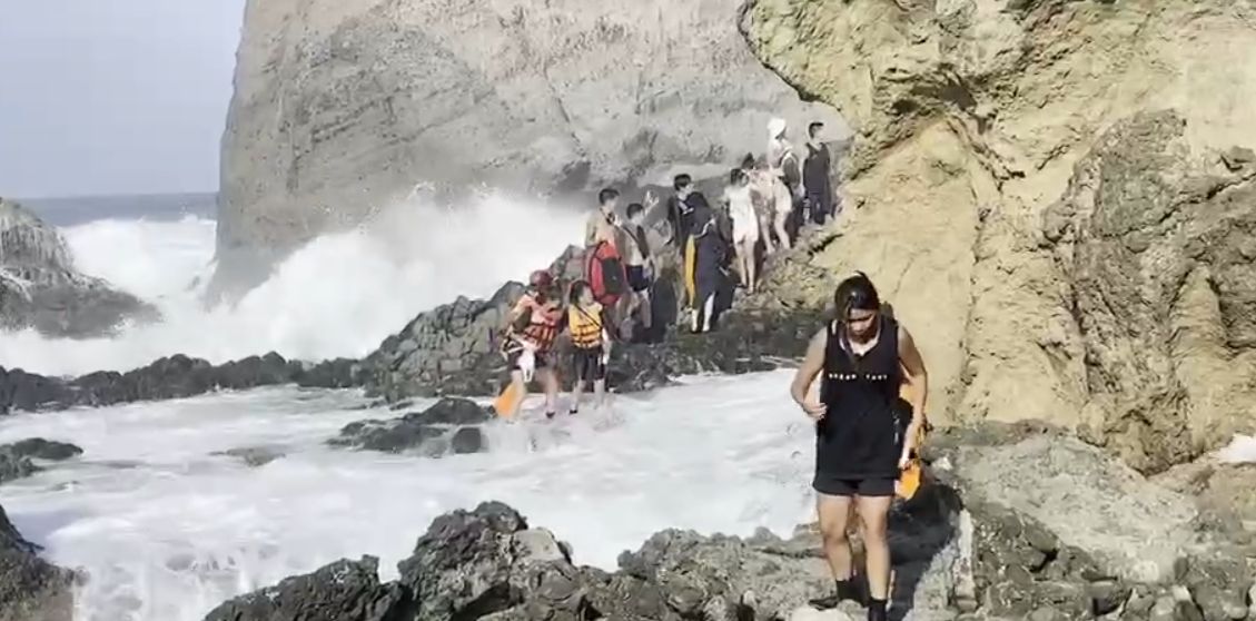▲台東綠島傳出有遊客差點遭浪捲走，12日下午約4點，海巡人員到柚子湖勸導民眾，不要觀浪，沒想到馬上就遇到兩位觀浪民眾，被海浪襲擊落海，海巡人員立刻下海救援，成功將人救上岸。（圖／翻攝畫面）