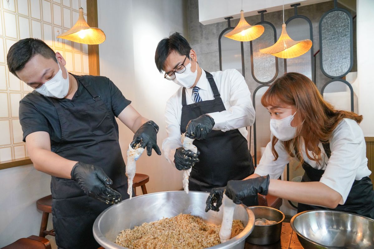 ▲陳其邁為挺青年創業今天化身美食總裁，與青年局長張以理跟店長一起包肉圓、灌糯米腸，親身體驗手路菜費工的多道程序。（圖／青年局提供）