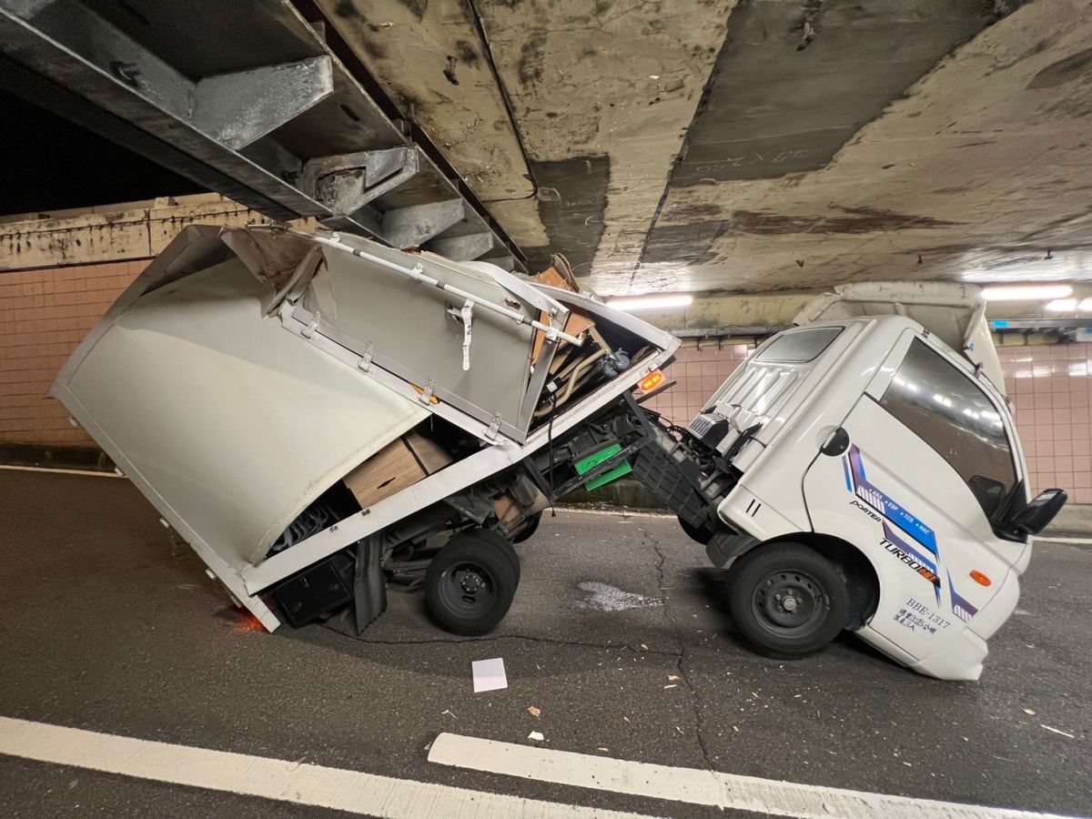 ▲一輛貨車駕駛開到基隆路隧道口，沒注意到限高，入隧道時後方的貨物箱，直接卡住隧道口。（圖／翻攝畫面）