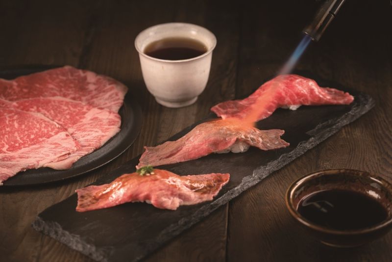 ▲薄片和牛炙燒後刷上特製醬料,「炙燒和牛壽司」是不少人造訪和牛涮必吃菜色。(圖/王品集團提供)