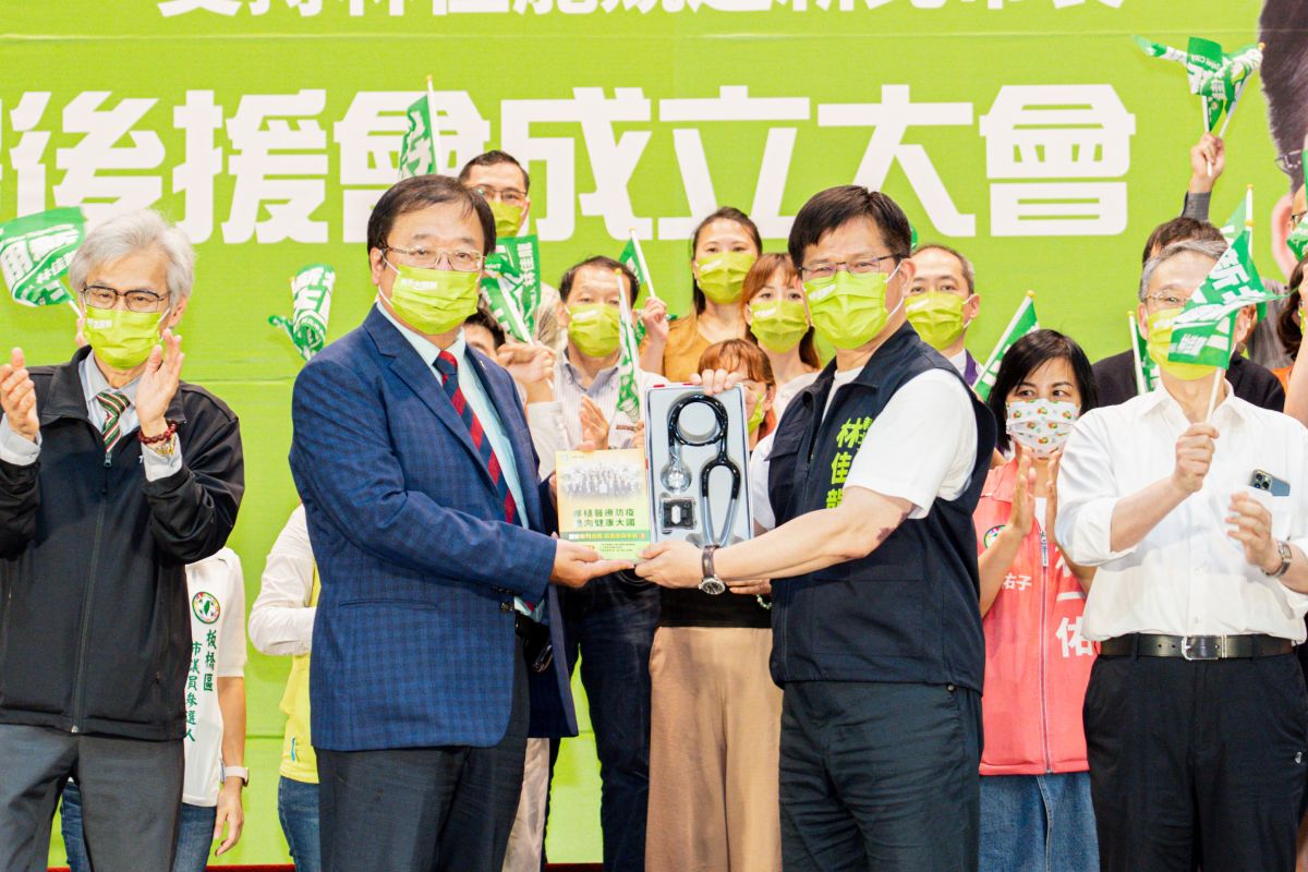 ▲林佳龍出席新北市醫事團體支持林佳龍後援會成立大會，從邱泰源手中接下象徵「傾聽民意、對市政對症下藥」的聽診器和醫療白皮書。（圖 ／林佳龍競選辦公室提供）