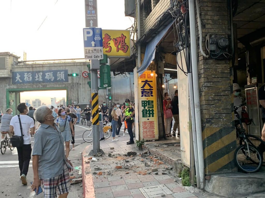 ▲台北市大稻埕碼頭附近一處閒置老屋2日下午發生水泥塊掉落事件，一名路過女性遭砸傷頭部，警消獲報到場協助送醫，人行道上水泥塊散落一地，目前現場已拉起封鎖線管制。（圖／中央社）