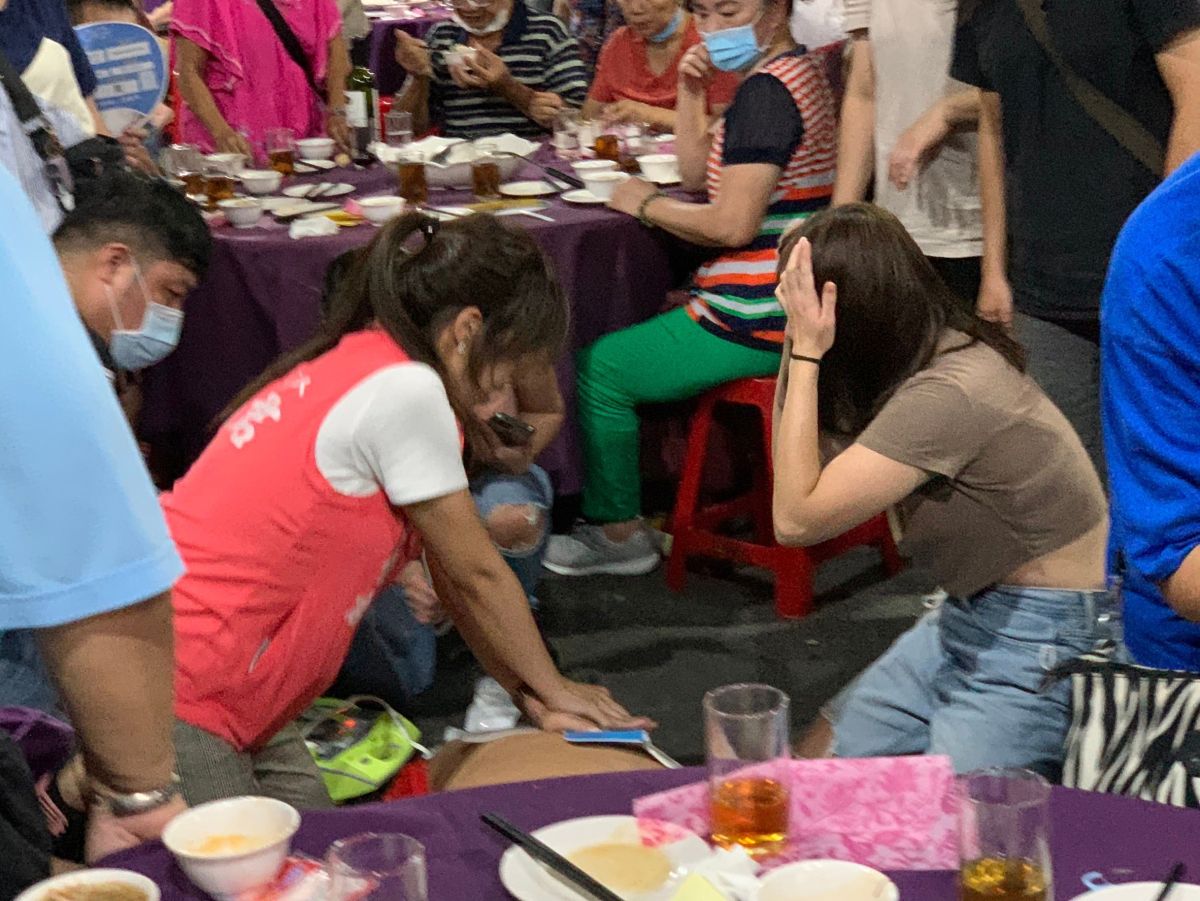 ▲台北市環南市場餐會上一位民眾突然倒地，華江里長參選人洪佳君（圖左）立即上前實施CPR心肺復甦術。（圖／翻攝畫面）