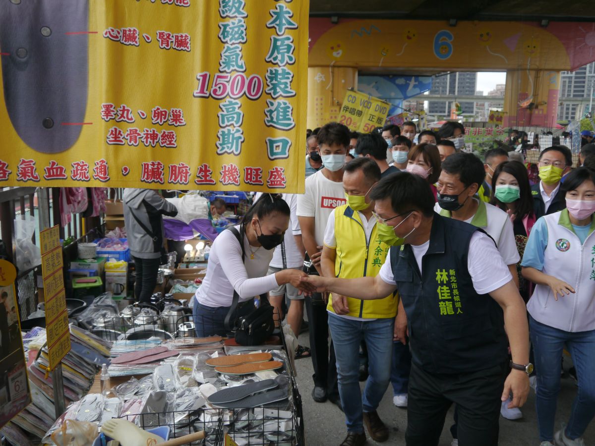 ▲林佳龍在同黨市議員候選人陪同下，到三重重新橋觀光市集掃街拜票，向攤商及民眾握手或拱手致意。（圖 ／記者吳嘉億攝，2022.10.9）