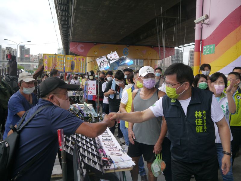 ▲林佳龍在同黨市議員候選人陪同下，到三重重新橋觀光市集掃街拜票，向攤商及民眾握手或拱手致意。（圖 ／記者吳嘉億攝，2022.10.9）