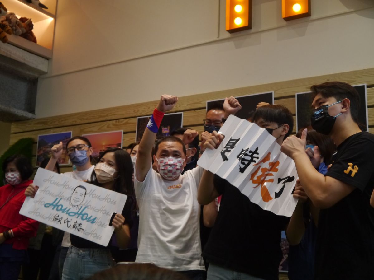 ▲侯友宜競選總部成立，政治實習生與侯友宜合照並展示創意文宣品吸引目光。（圖 ／記者吳嘉億攝，2022.10.10）