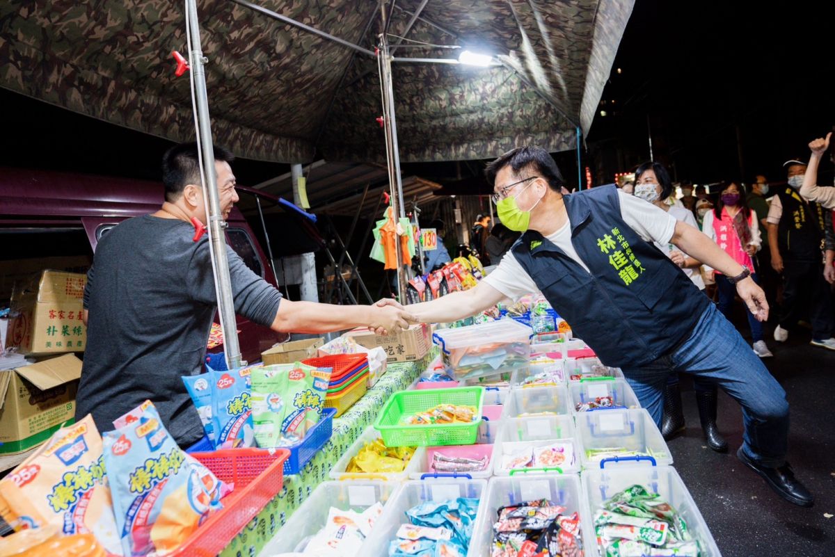 ▲林佳龍晚間前往板橋湳雅夜市掃街拜票，儘管現場稍有雨勢，民眾也以握手方式向林佳龍加油打氣。（圖 ／林佳龍競選辦公室提供）