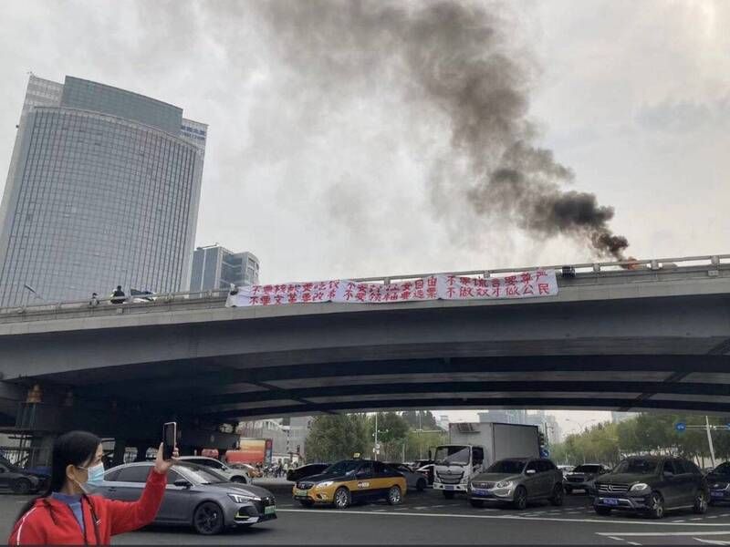 ▲北京四通橋13日被掛上反習標語，還有人燃燒東西抗議，相關畫面在網路上瘋傳。（圖／翻攝自推特）