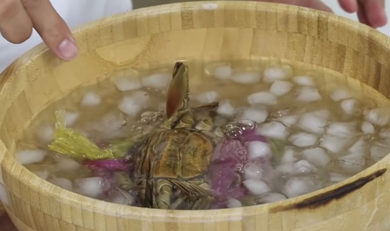 ▲阿慶師指出，所有螃蟹在家烹煮前都要先將外殼剝開，建議料理前準備一鍋溫度極低的冰水，並加入些許的鹽，然後將螃蟹倒放下去凍暈。（圖／阿慶師提供）