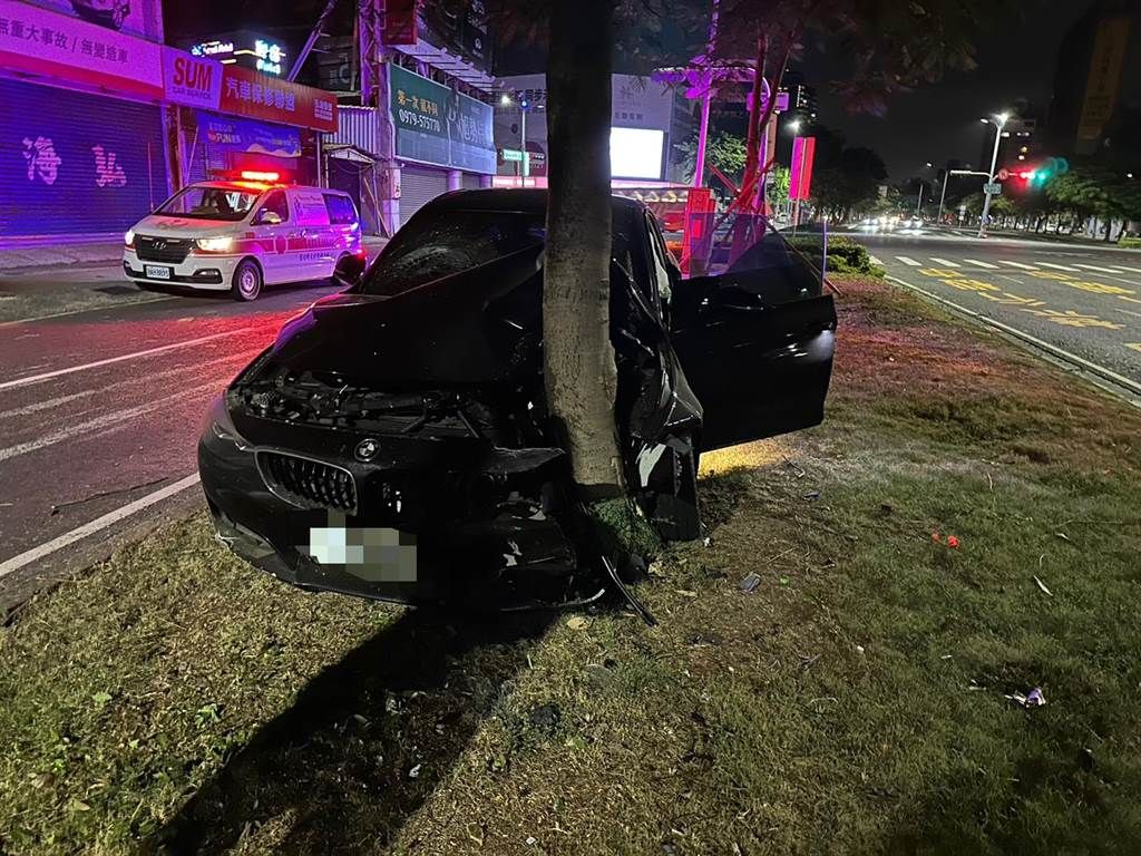 ▲高雄市三民區昨（19）晚深夜，一輛BMW開上安全島自撞路樹，車頭扭曲包樹，安全氣囊也爆開。（圖／翻攝畫面）
