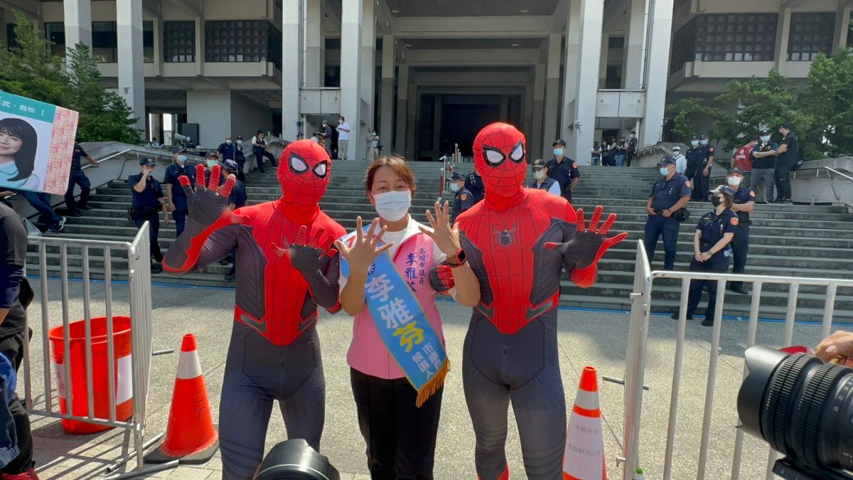 ▲高雄市議員候選人李雅芬今天上午抽中10號。她的老公、兒子化身蜘蛛人力挺。(圖／翻攝畫面)