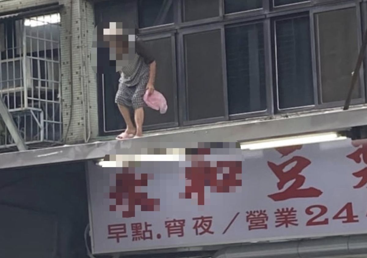 ▲有人目睹，就在早餐店的樓上屋簷上，竟站著一位阿嬤正拿著塑膠袋在低頭。（圖／翻攝自臉書「路上觀察學院」）