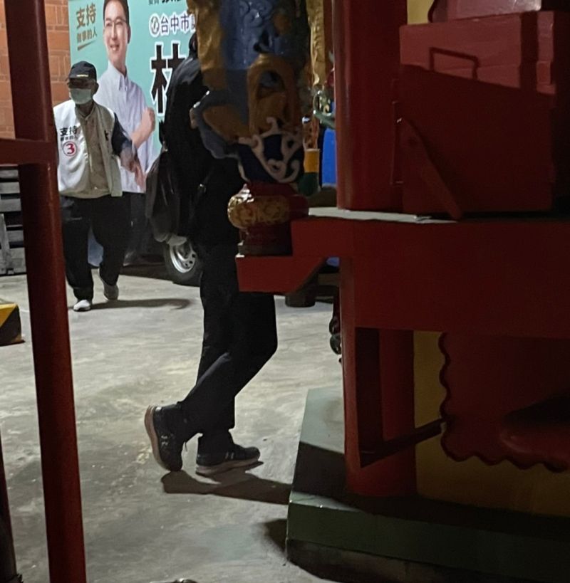 ▲陳姓主任不像一般民眾走進座談會場,反而躲在金爐後拍攝,怪異舉止引起工作人員注意。(圖/林祈烽提供,2022.10.26)