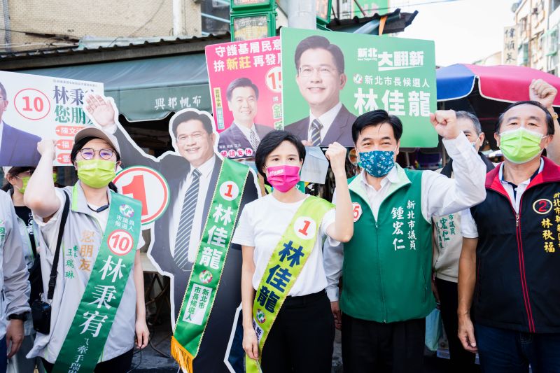▲鄭麗君背上林佳龍的競選背帶,在競選團隊及市議員候選人陪同下,到新莊裕民市場掃街拜票。(圖 /林佳龍競選辦公室提供)