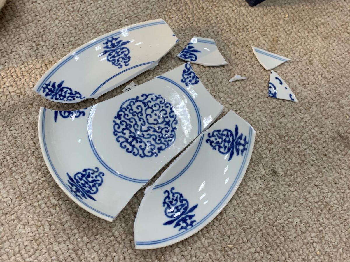 ▲故宮人員在整理文物時疏忽，導致「清 乾隆 青花花卉盤」掉落破損。（圖／故宮提供）