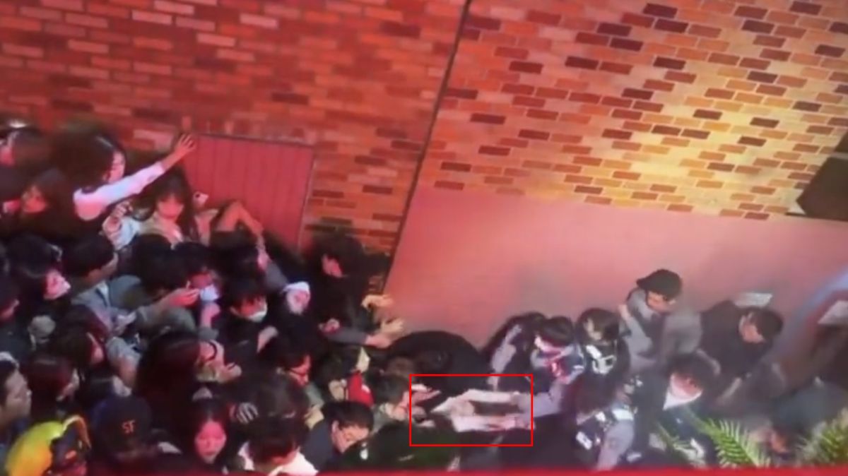 ▲梨泰院29日發生踩踏事故，一名隊伍最前端的女子被上百人卡死，臉色發白警消救不出。（圖/推特＠meimei9981）