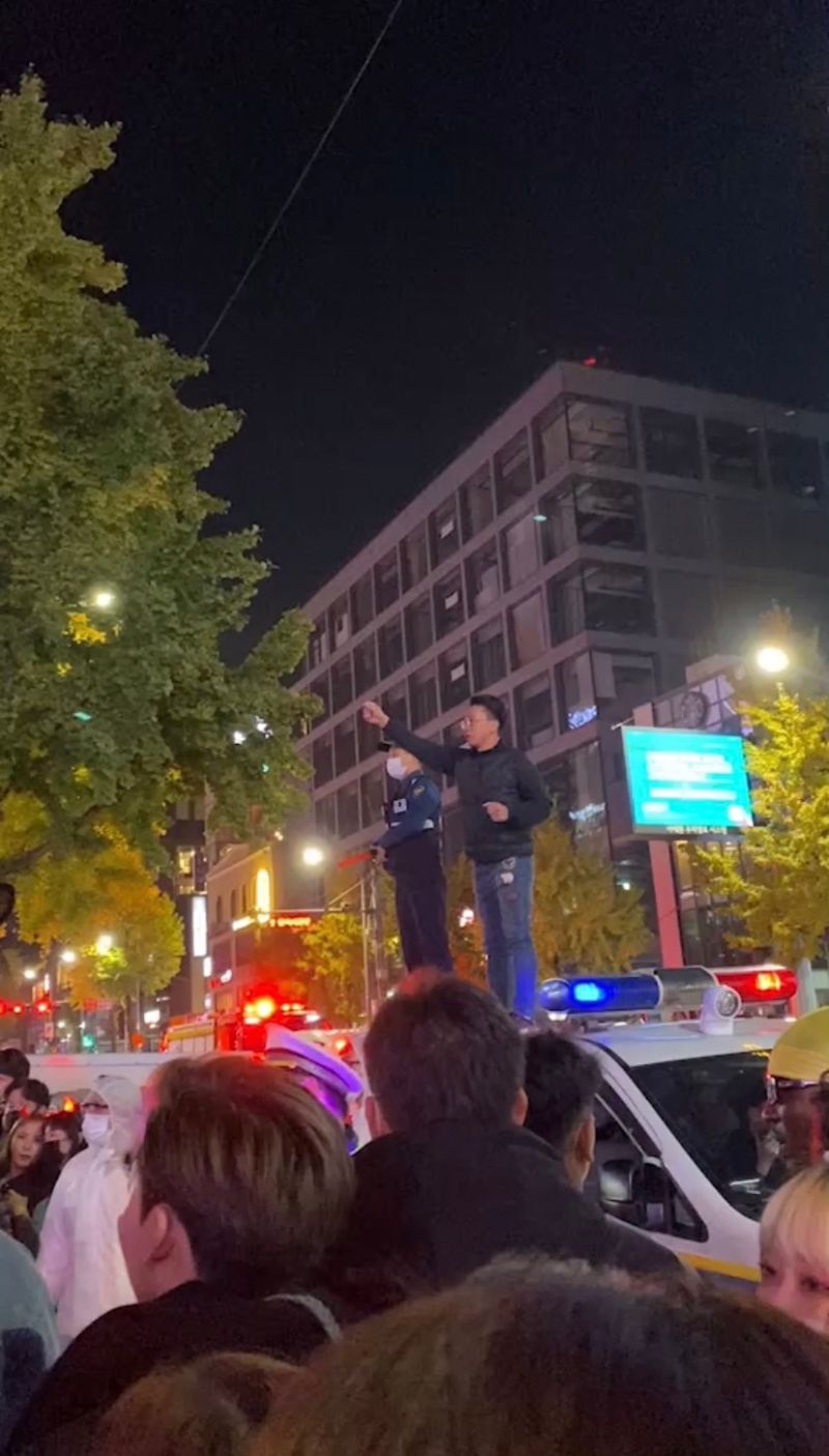 ▲梨泰院當天人潮太多,警員甚至踩上警車疏散民眾。(圖/受訪民眾提供)