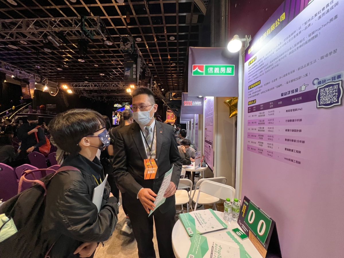 ▲「T大使」畢業典禮暨就業媒合嘉年華首度恢復實體舉辦，信義房屋創新研發部執行經理施閔堯（右）向青年說明職缺內容。（圖／NOWnews資料照片）