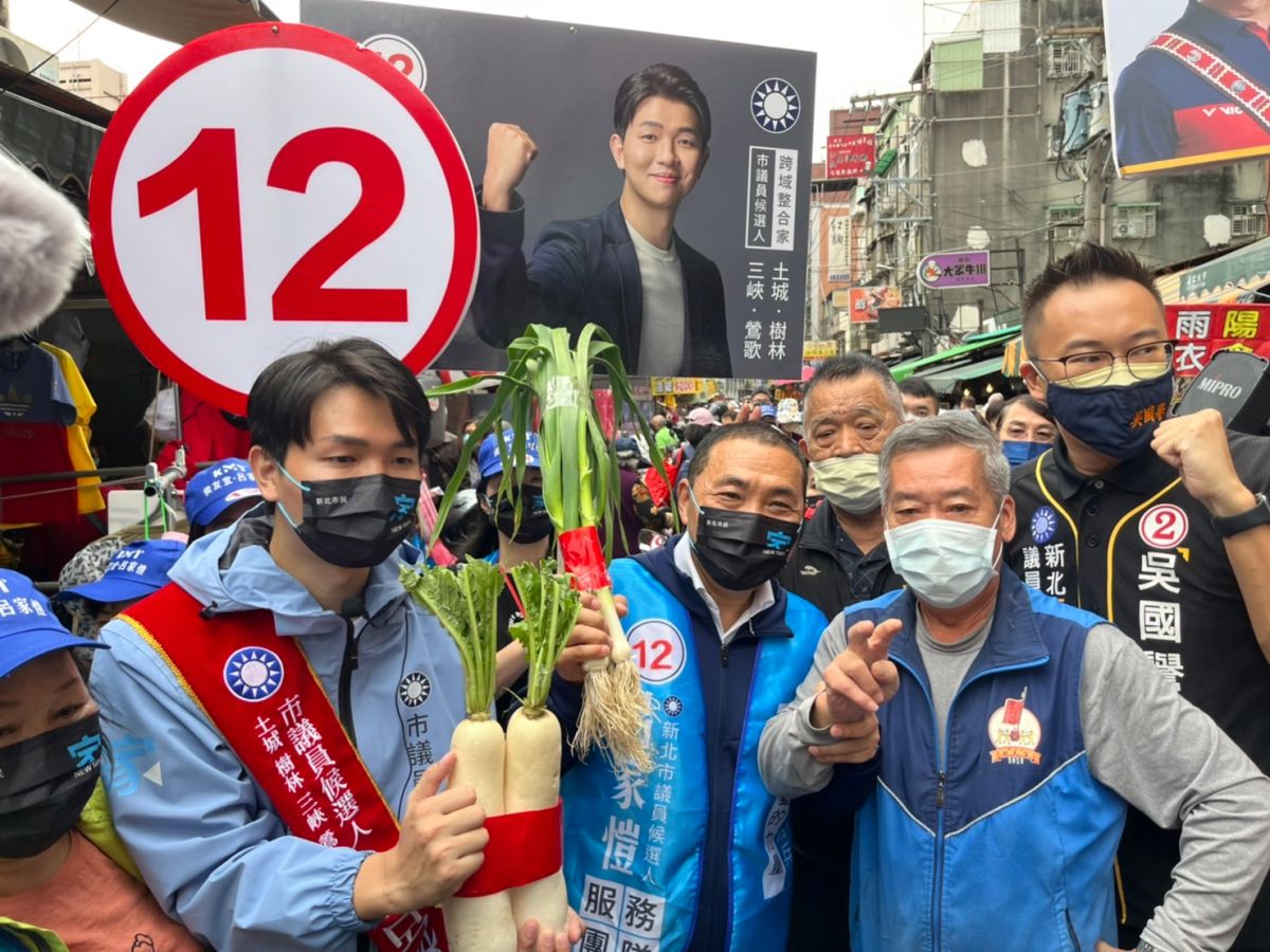 ▲侯友宜與「侯家軍」子弟兵呂家愷一同掃街拜票，支持群眾送上蒜跟象徵好彩頭的蘿蔔，預祝順利當選。（圖 ／記者吳嘉億攝，2022.11.2）