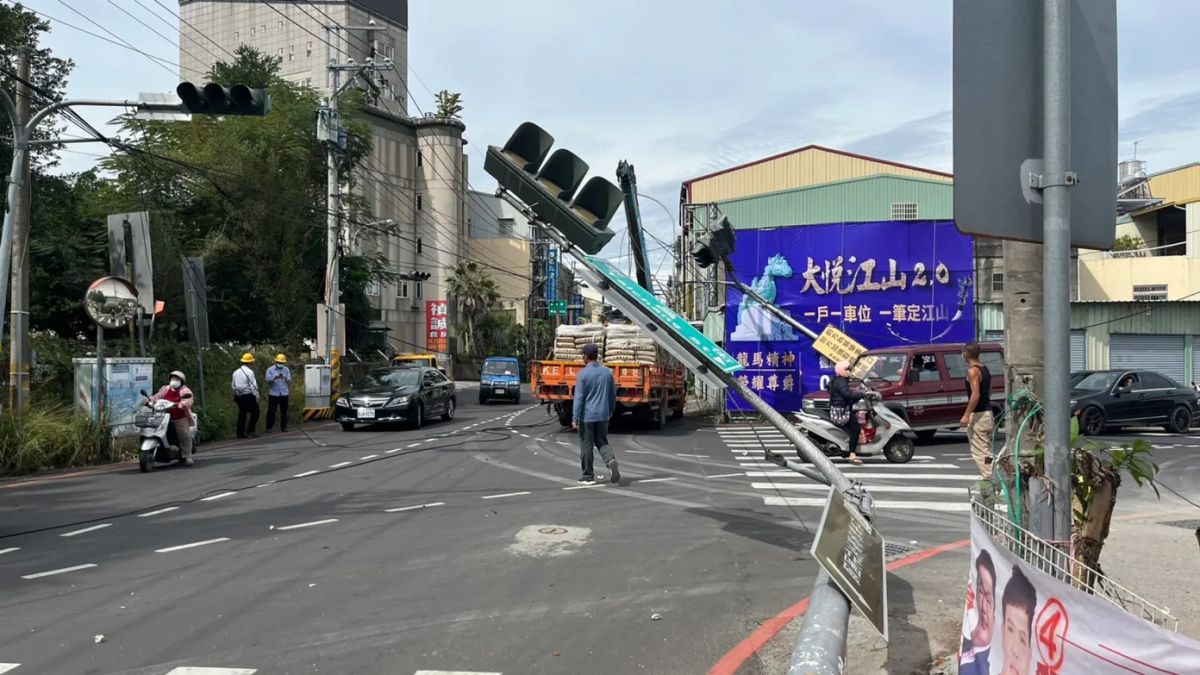 ▲台中市東勢區泰昌街與東坑路口，今日中午一輛大貨車上路時忘了把吊桿收好，拉扯電線將兩支紅綠燈拉彎倒地。（圖／翻攝自記者爆料網）