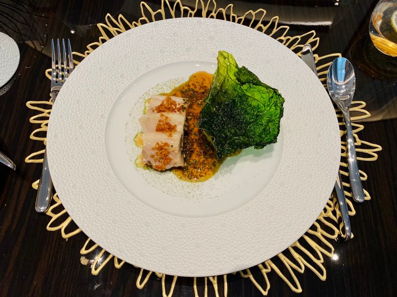 ▲使用屏東本地黑豬肉的「脆皮豬腹配燉煮包心菜黑松露醬汁」,舒肥軟嫩的肉質搭配烤至香脆的豬皮,與豬肉肉汁搭配松露與雪莉醋醬汁一起越嚼越香,還有油封皺葉甘藍脆片與高麗菜碎洋芋泥可混搭口感。(圖/記者蕭涵云攝)