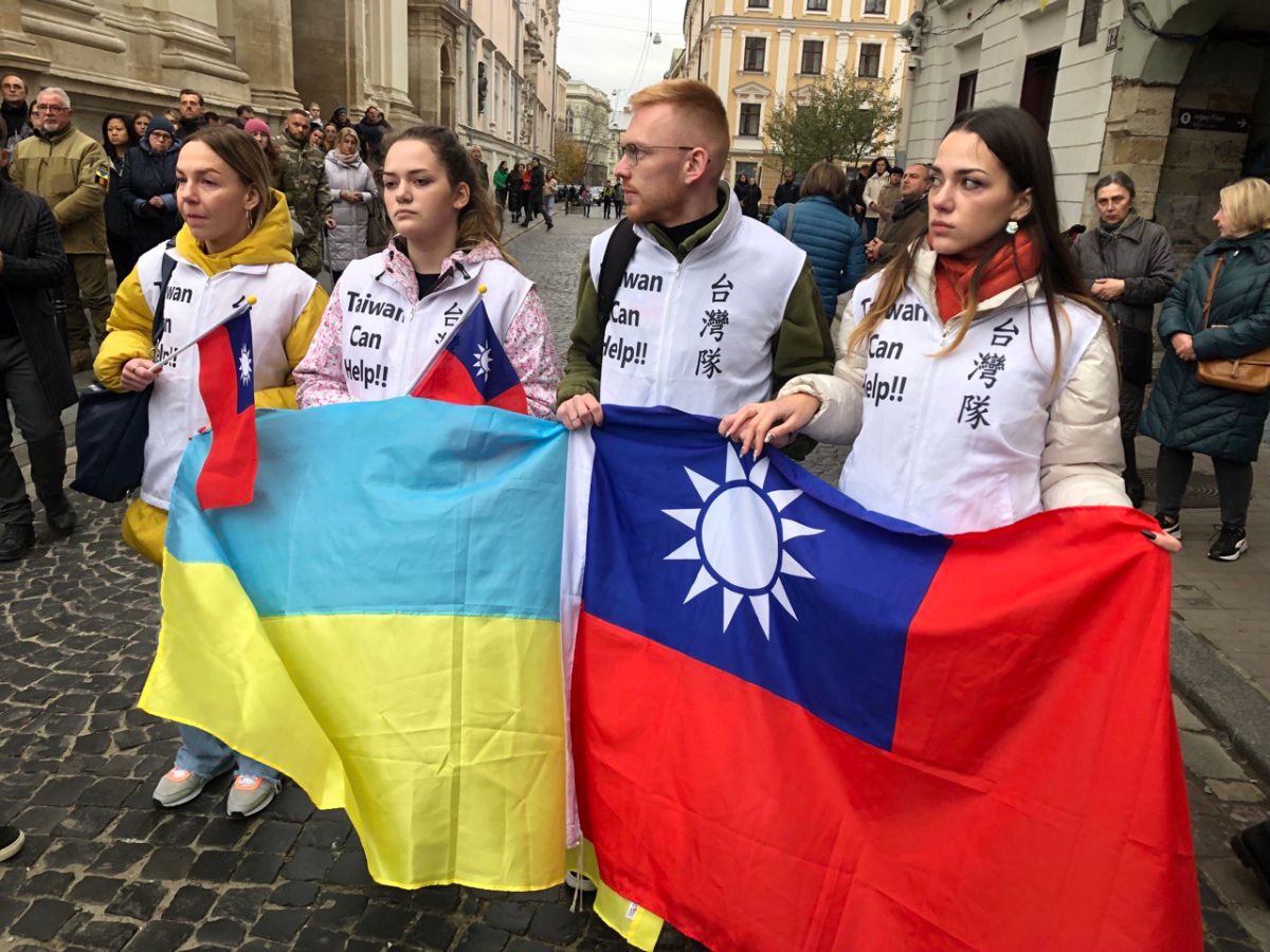 ▲烏克蘭軍方在利維夫市為罹難的台灣志願軍曾聖光舉行追思儀式，烏克蘭民眾拿著中華民國國旗與烏克蘭國旗，在寒風中夾道送曾聖光最後一程。（圖／外交部提供）