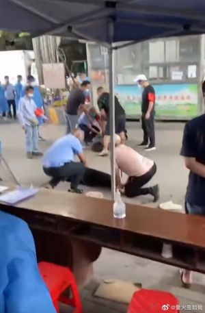 防疫人員及群眾將兩名女子按倒在地。(圖/微博:螢火蟲如我) ▲防疫人員及群眾將兩名女子按倒在地。(圖/微博:螢火蟲如我)