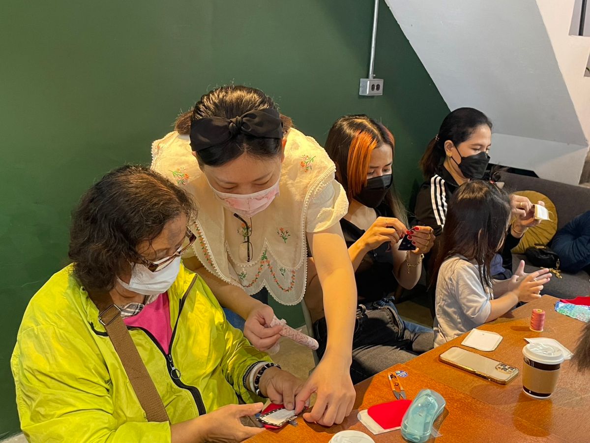 ▲新住民認真縫製零錢包。（圖／移民署提供）