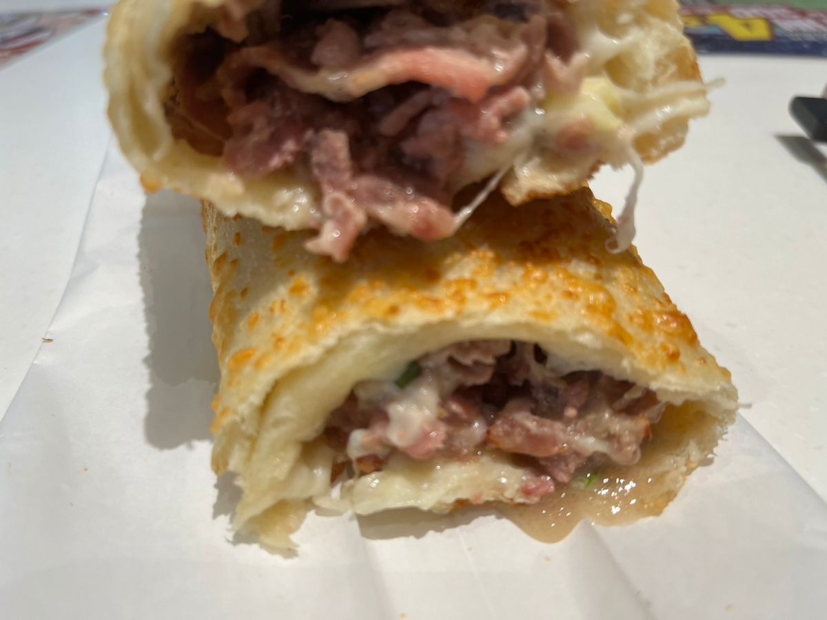 ▲好市多熟食區新品豬肉捲，趁熱撥開會有乳酪牽絲、流肉汁。（圖／記者鍾怡婷攝）