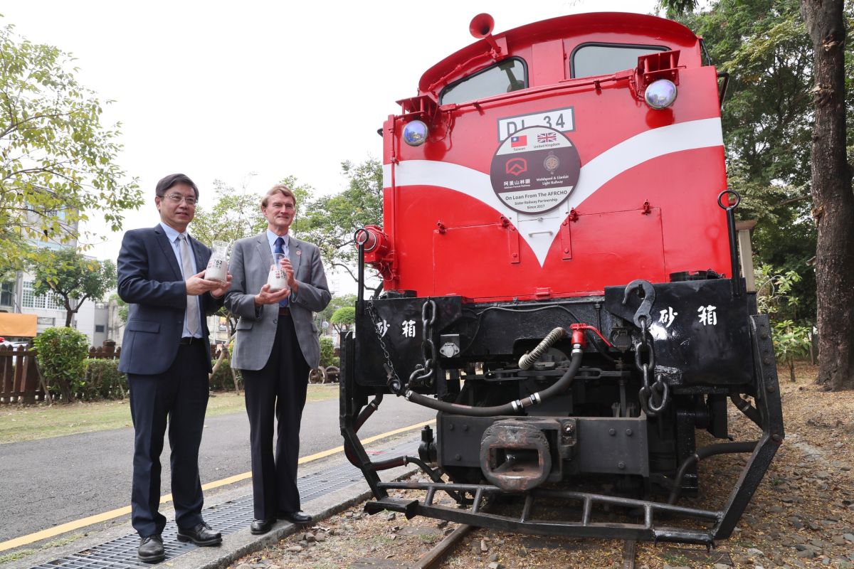 ▲台英代表倒入止滑矽沙，祝福DL-34平安抵達英國。（圖／林務局提供）