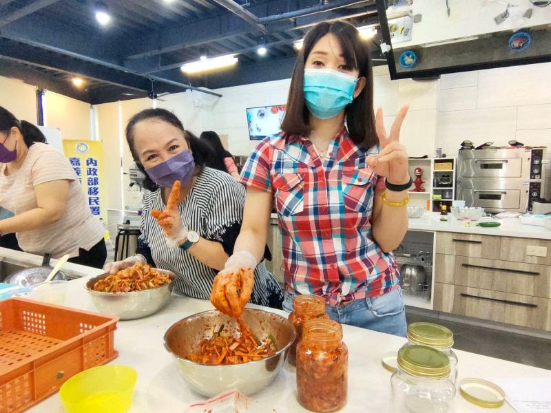 ▲印尼新住民琪燕(右)開心地將做好的泡菜分裝置密封罐內保存。（圖／移民署提供）